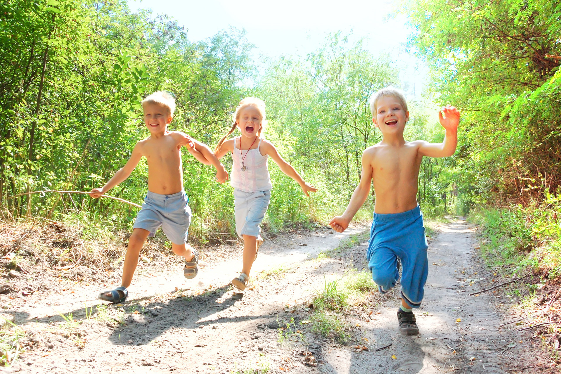 group of 5-6 year old happy kids running in the woods